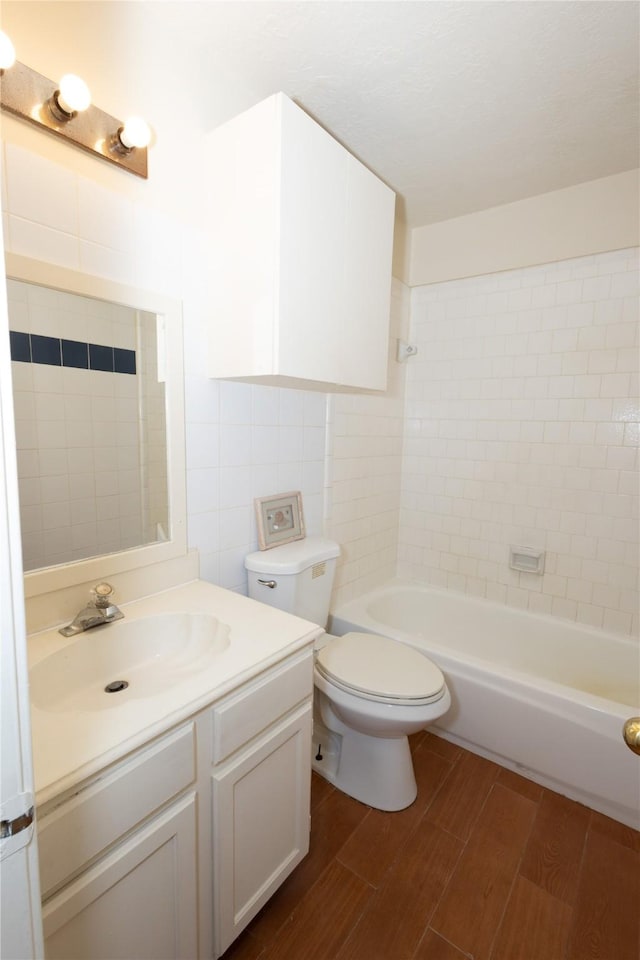 bathroom with toilet, vanity, shower / tub combination, and wood finished floors