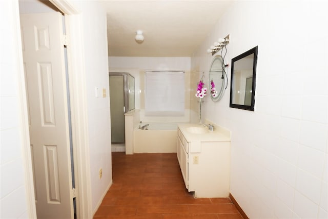 hallway with a sink, tile walls, and wood finished floors