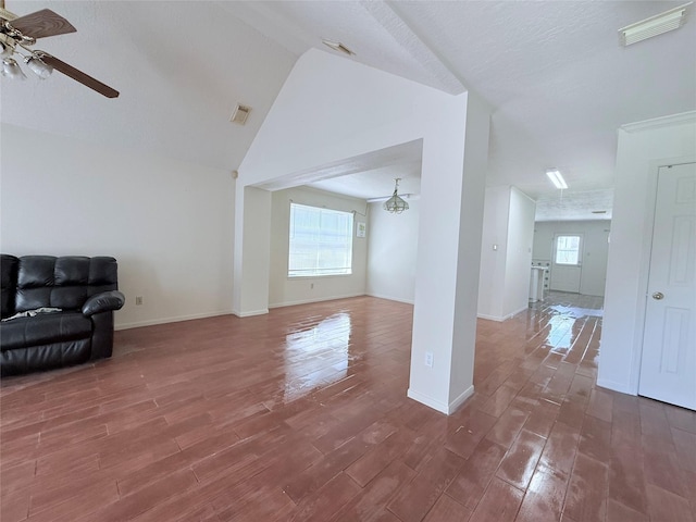 unfurnished living room featuring lofted ceiling, wood finished floors, visible vents, and ceiling fan