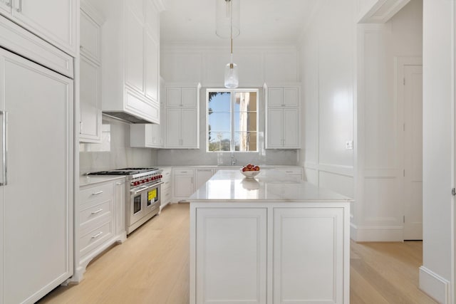 kitchen featuring decorative light fixtures, a center island, range with two ovens, and white cabinets