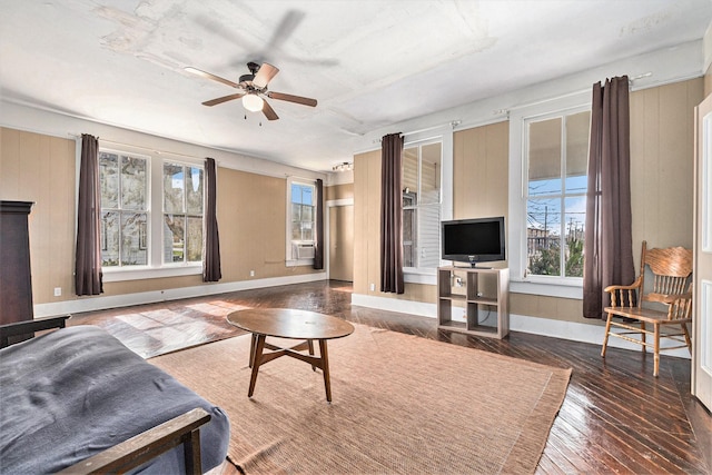 living room with dark hardwood / wood-style flooring and ceiling fan