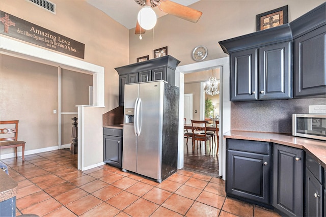 kitchen with stainless steel appliances, tasteful backsplash, ceiling fan with notable chandelier, and light tile patterned floors