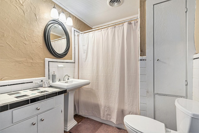 full bathroom with sink, shower / tub combo, and toilet