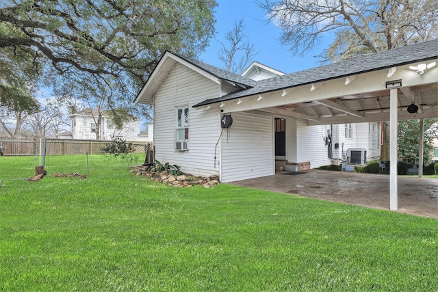 exterior space featuring cooling unit, a carport, a yard, and central AC unit