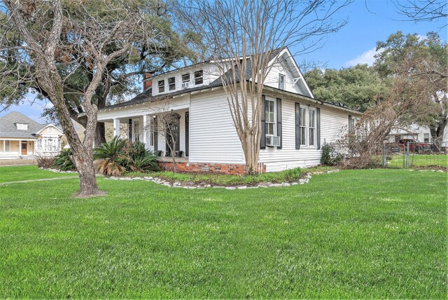 view of front of property featuring a front yard, covered porch, and cooling unit