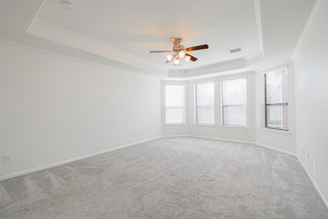 carpeted empty room featuring crown molding, ceiling fan, and a tray ceiling