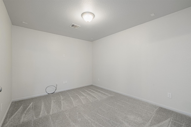 carpeted empty room with a textured ceiling