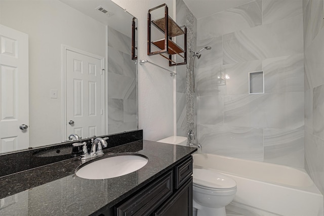 full bathroom with tiled shower / bath, vanity, and toilet