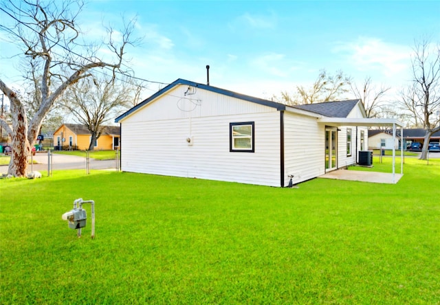 view of side of property featuring central AC, a yard, and a patio area