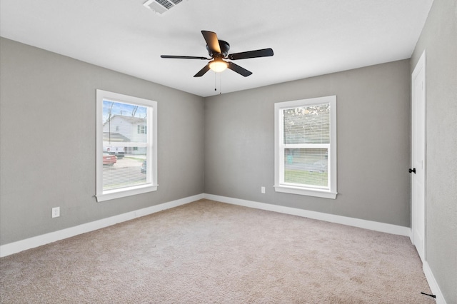 empty room featuring ceiling fan and light carpet