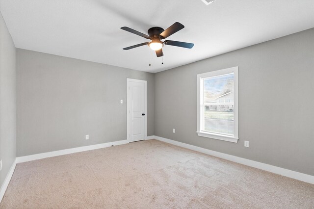 spare room featuring light carpet and ceiling fan