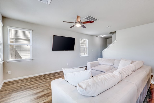 living room with hardwood / wood-style flooring, ceiling fan, and a healthy amount of sunlight