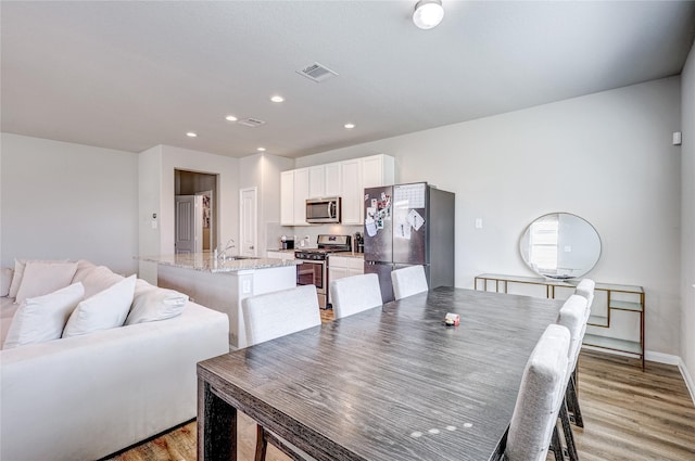 dining space featuring sink and light hardwood / wood-style flooring