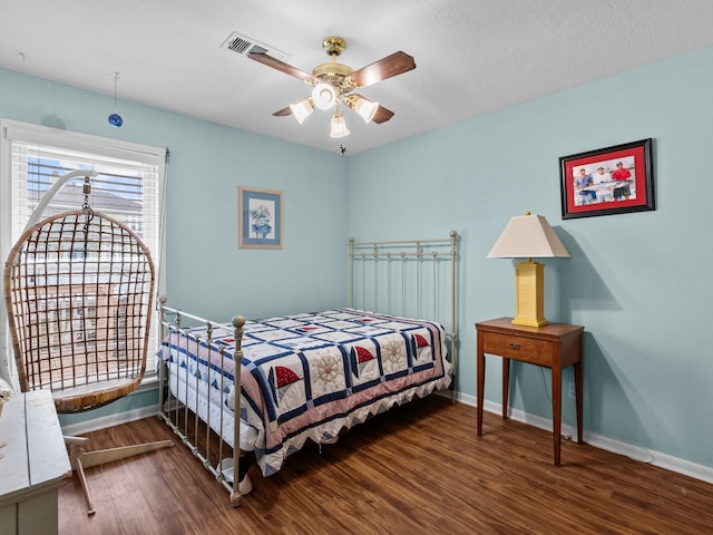 bedroom with dark wood-type flooring, a textured ceiling, and ceiling fan