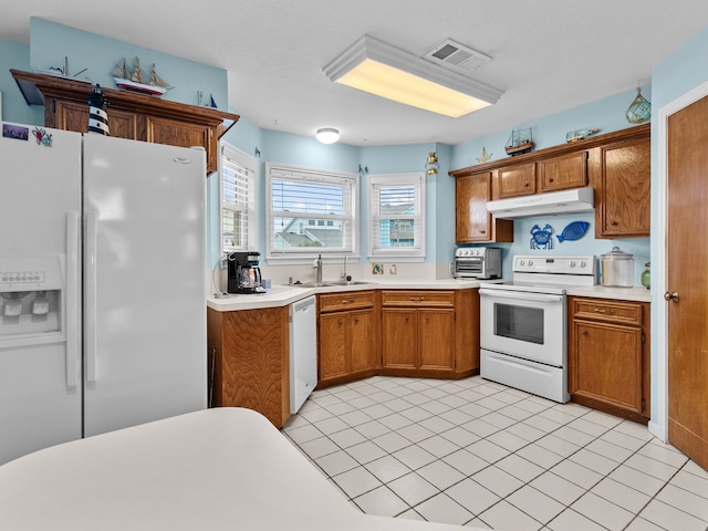 kitchen with sink, light tile patterned floors, and white appliances