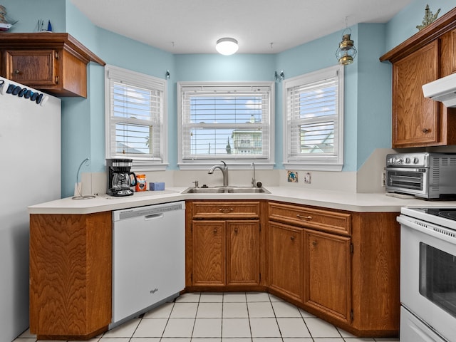 kitchen with sink, white appliances, plenty of natural light, and kitchen peninsula