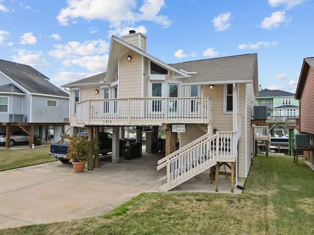 rear view of house featuring a carport, central AC unit, a deck, and a lawn