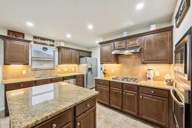 kitchen with sink, tasteful backsplash, light tile patterned floors, stainless steel appliances, and light stone countertops