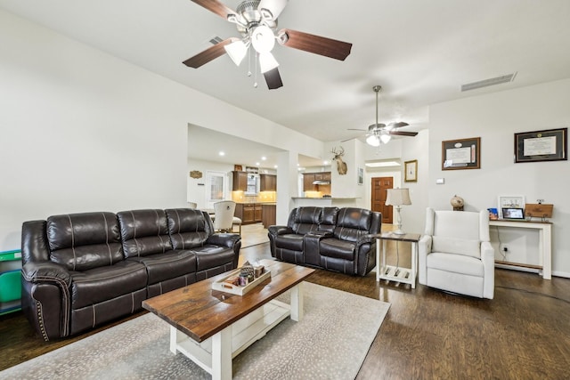 living room featuring ceiling fan and dark hardwood / wood-style floors