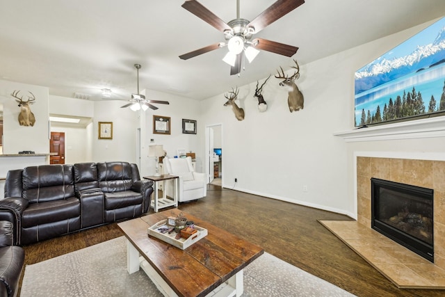 living room with dark wood-type flooring, a fireplace, and ceiling fan