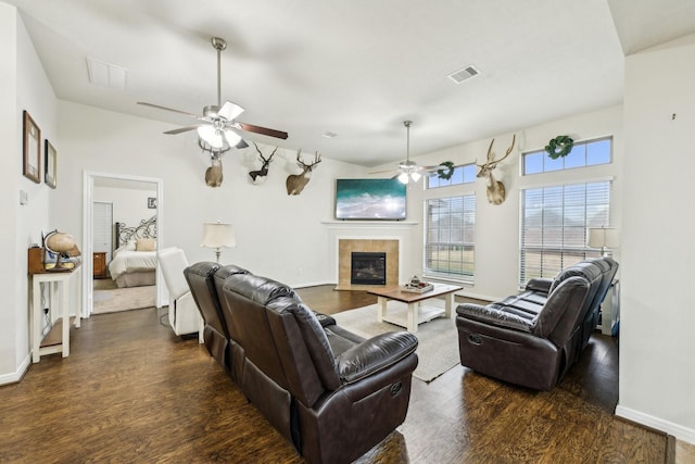 living room featuring a tile fireplace, ceiling fan, and dark hardwood / wood-style flooring