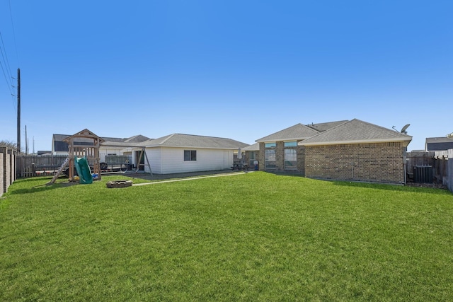 view of yard with a playground, central air condition unit, and an outdoor fire pit