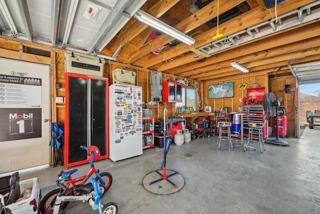 garage with a workshop area and white fridge