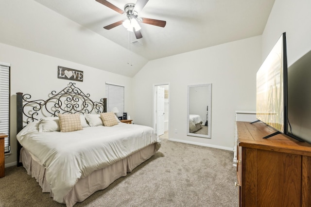 carpeted bedroom with ceiling fan, lofted ceiling, and ensuite bath