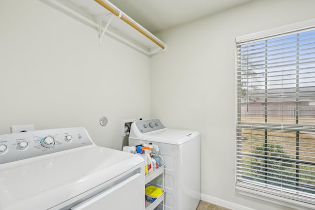 laundry room with washing machine and clothes dryer and a healthy amount of sunlight