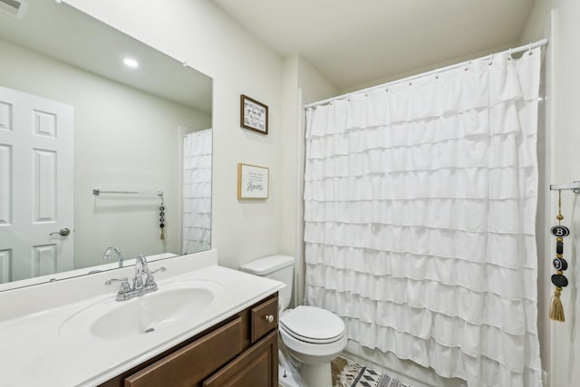 bathroom with vanity, curtained shower, and toilet