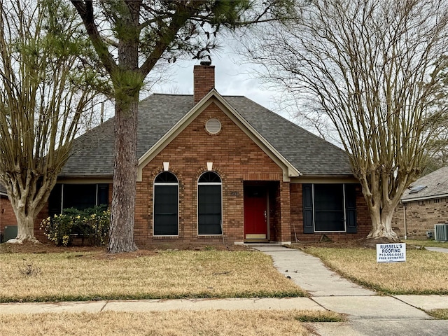 view of front of house with cooling unit and a front lawn