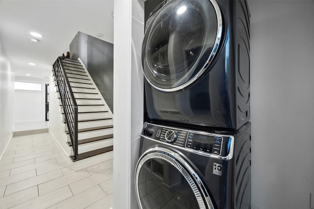 clothes washing area featuring laundry area, recessed lighting, and stacked washer / drying machine