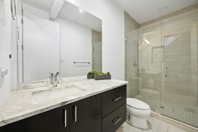 bathroom with vanity, a shower with shower door, tile patterned floors, and toilet