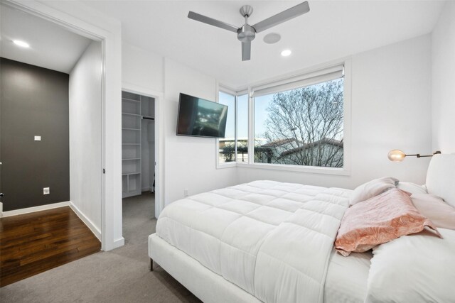 bedroom featuring ceiling fan, recessed lighting, baseboards, carpet, and a walk in closet