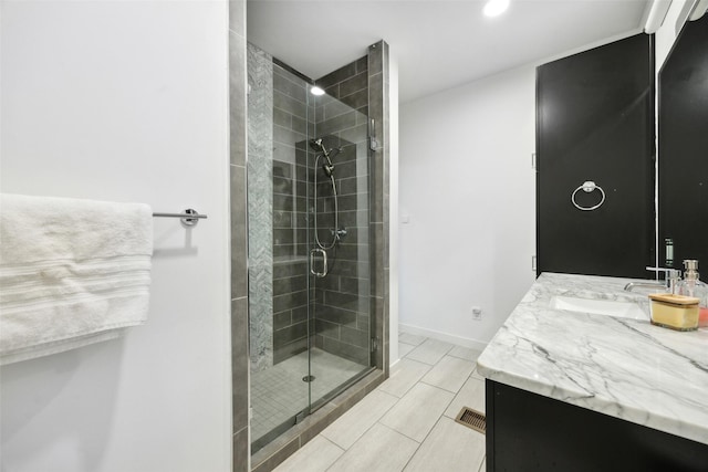 bathroom with a shower stall, visible vents, baseboards, and vanity