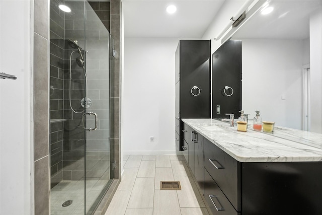 full bathroom with visible vents, baseboards, vanity, a shower stall, and recessed lighting