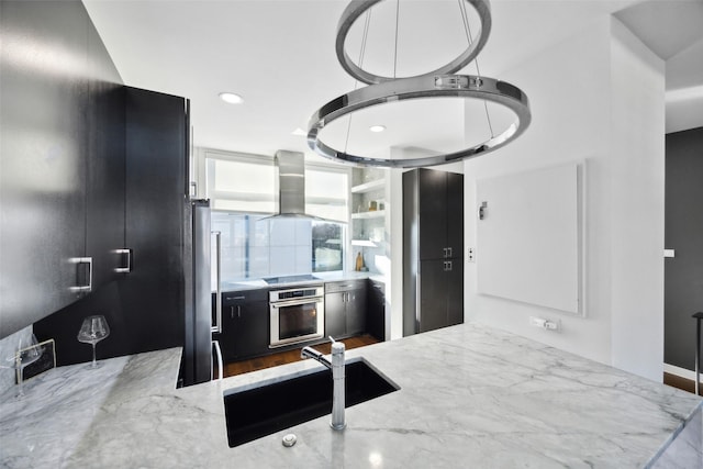 kitchen with ventilation hood, sink, oven, black electric stovetop, and light stone counters