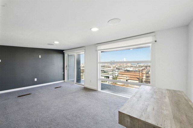 carpeted empty room featuring baseboards, visible vents, and recessed lighting