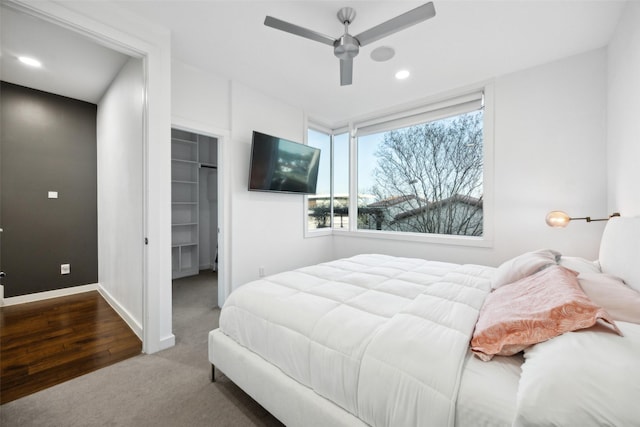 carpeted bedroom with a spacious closet, a closet, and ceiling fan