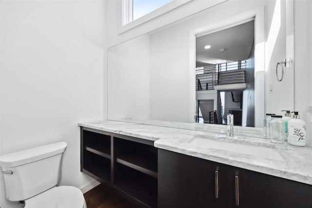 bathroom with vanity, toilet, and hardwood / wood-style floors