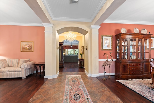 foyer entrance with crown molding, dark wood-type flooring, and ornate columns