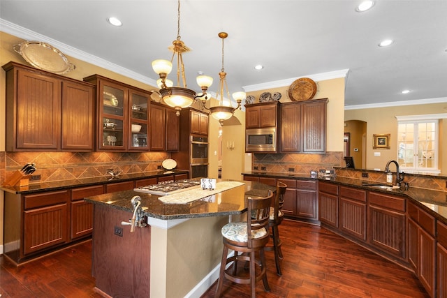 7514 Saddle Blanket Dr, Waller, TX 77484 - kitchen with stainless steel appliances, a sink, arched walkways, dark wood-style flooring, and recessed lighting