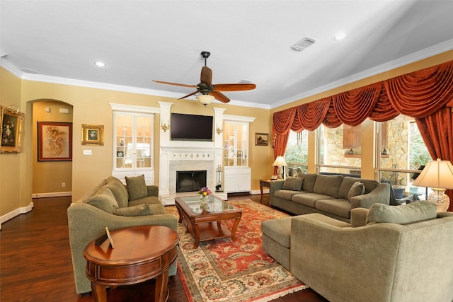 living room featuring dark wood-type flooring, ceiling fan, and crown molding