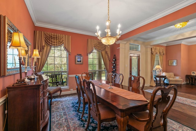 dining room with ornate columns, crown molding, dark wood-type flooring, and an inviting chandelier