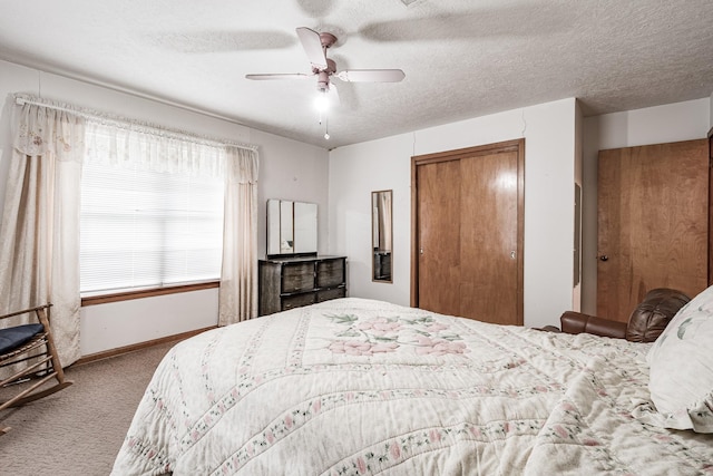 bedroom featuring ceiling fan, a closet, light carpet, and a textured ceiling