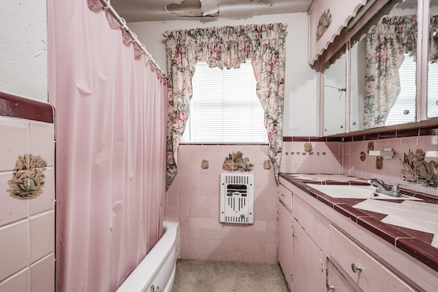 bathroom with vanity, tile walls, and shower / bath combo