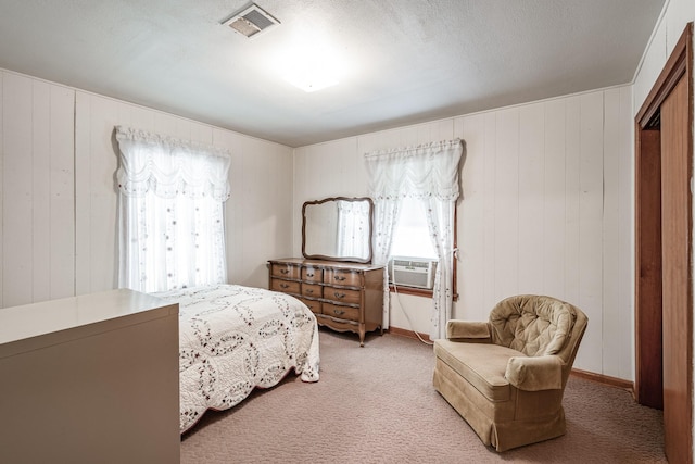 carpeted bedroom featuring cooling unit and a textured ceiling