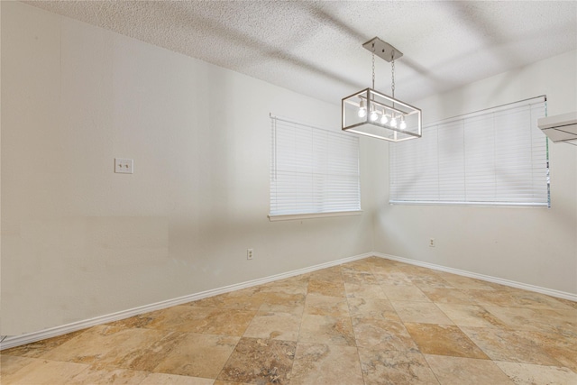 unfurnished dining area with a textured ceiling