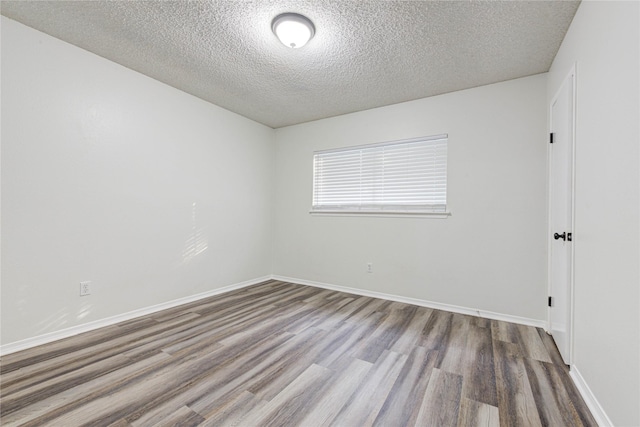 spare room with hardwood / wood-style floors and a textured ceiling