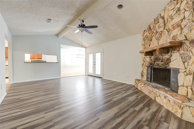 unfurnished living room with a fireplace, vaulted ceiling with beams, dark hardwood / wood-style flooring, ceiling fan, and a textured ceiling